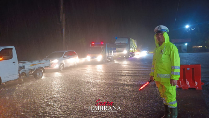 Personel Unit Lantas Polsek Negara Atur Arus Kendaraan di Tengah Hujan Deras